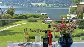 Gemütlich gedeckter Terrassentisch mit Blick auf den See und die umliegende Berglandschaft.