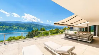 Geräumige Terrasse mit bequemen Lounge-Möbeln, Sonnenliegen und einem atemberaubenden Blick auf den See und die Berge.
