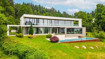 Moderne Villa mit großen Glasfronten, Infinity-Pool und weitläufigem Garten in grüner Hügellandschaft.