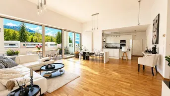 Heller, offener Wohn-Essbereich mit moderner Küche, Parkettboden und Zugang zum Balkon.