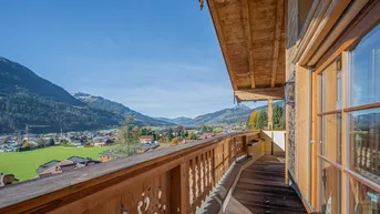Großer Holzbalkon mit Panoramablick auf die Berge und das Tal.