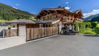 Traditionelles Holzchalet mit moderner Architektur und gepflegtem Eingangsbereich in alpiner Umgebung.