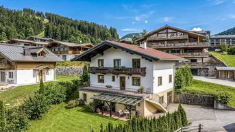 Charmantes Haus mit Garten, überdachter Terrasse und Bergblick in alpiner Umgebung.