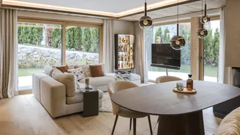 Helles, modernes Wohn-Esszimmer mit Holzboden, großen Fenstern und Zugang zum Garten.