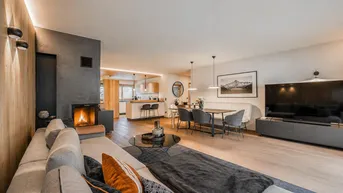 Modernes offenes Wohnzimmer mit Kamin, Essbereich und integrierter Küche.