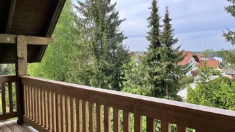 Geräumiger Holzbalkon mit weitem Blick ins Grüne und auf die umliegende Wohnbebauung.