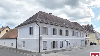 Historisches Gebäude mit hellblauer Fassade, vielen Fenstern und traditionellen Fensterläden.