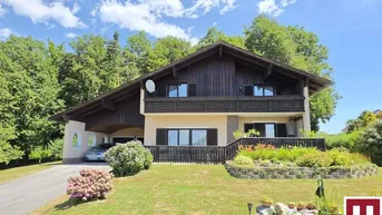 Traditionelles Haus im alpenländischen Stil mit Holzfassade, großem Vorgarten und Carport.