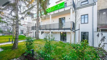 Modernes Neubau-Mehrfamilienhaus mit Balkonen und gepflegter Grünanlage im Vordergrund.