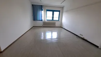 Leerer Raum mit weißen Wänden, einem Fenster mit blauen Vorhängen und einem Heizkörper.