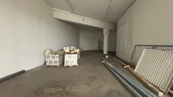 Großer, leerer Gewerberaum mit Betonboden und sichtbaren Installationen, bereit für den Ausbau.