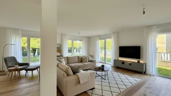 Helles, modern eingerichtetes Wohnzimmer mit Parkettboden, beigen Sofas und Zugang zum Garten.