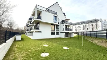 Modernes weißes Mehrfamilienhaus mit Balkonen und gepflegter Rasenfläche in einer Wohngegend.