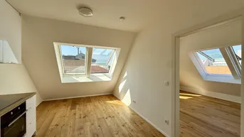 Heller Wohnbereich mit Holzboden, Dachschrägen und zwei großen Dachfenstern, die viel Licht hereinlassen.