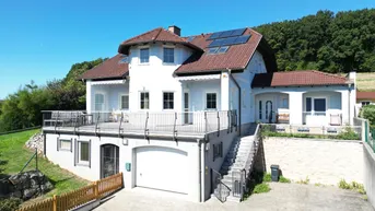 Großzügiges Einfamilienhaus mit Garage, Terrasse und Photovoltaikanlage auf dem Dach.