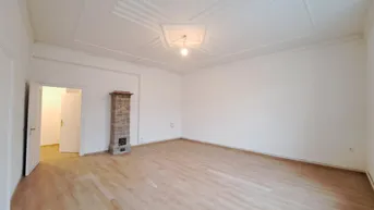 Geräumiges, leeres Wohnzimmer mit hellem Laminatboden und dekorativer Deckenverzierung.