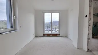 Unfertiges Schlafzimmer mit französischem Balkon und weitem Blick in die grüne Landschaft.