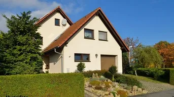 Gut gepflegtes Einfamilienhaus mit Satteldach, Garage, gepflegtem Vorgarten und sonniger Auffahrt.