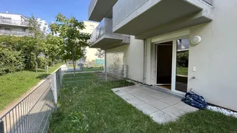 Privater Gartenbereich mit kleiner Terrasse und Zugang zu einem modernen Wohngebäude.