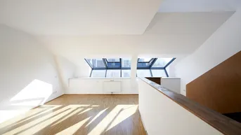 Heller Wohnbereich mit Dachfenstern, Holzboden und viel natürlichem Licht.