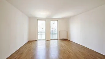 Geräumiges, helles Zimmer mit Parkettboden und zwei französischen Balkonen, die viel Licht hereinlassen.