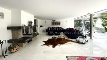 Geräumiger Wohnbereich mit Marmorboden, modernem Kamin und gemütlichen Sofas für entspannte Abende.