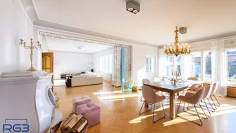 Helles, offenes Wohn- und Esszimmer mit Fischgrätparkett, Kamin und großem Esstisch.