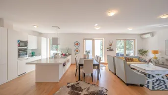 Heller, offener Wohn- und Essbereich mit moderner Küche und Zugang zum Balkon.