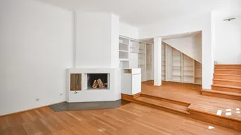 Gemütliches Wohnzimmer mit modernem Kamin, Holzparkettboden und integrierten Regalen.