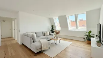 Helles Wohnzimmer mit modernem Sofa, Holzboden und Dachfenstern, die viel Licht hereinlassen.