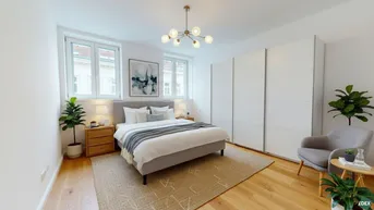 Helles Schlafzimmer mit Doppelbett, Schiebetürenschrank und Holzboden.