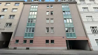 Gebäudefassade eines Mehrfamilienhauses mit modernen Fenstern und Balkonen in städtischer Umgebung.