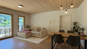 Heller offener Wohn- und Essbereich mit Holzboden, Holzdecke und Zugang zur Terrasse.