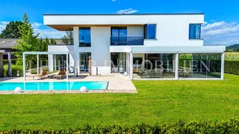 Weitläufiger Gartenbereich mit modernem Pool und gepflegtem Rasen vor der zeitgenössischen Villa.