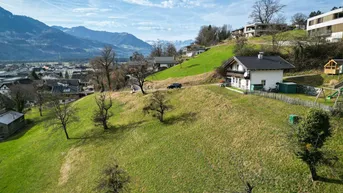 Luftaufnahme eines Hauses auf einem grünen Hügel mit beeindruckendem Bergblick im Hintergrund.