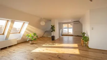 Helles, geräumiges Zimmer mit Holzboden, Dachfenstern und Zugang zu einem Außenbereich.