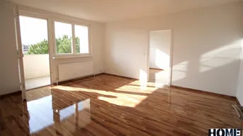Helles Wohnzimmer mit glänzendem Parkettboden und Zugang zu einem Balkon.