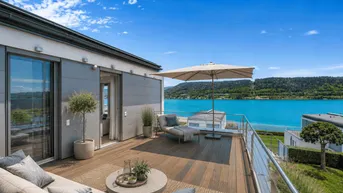 Große moderne Terrasse mit bequemen Lounge-Möbeln, Sonnenschirm und atemberaubendem Seeblick.