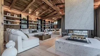Geräumiges Wohnzimmer mit Holzbalkendecke, modernem Kamin und bequemen Sofas.