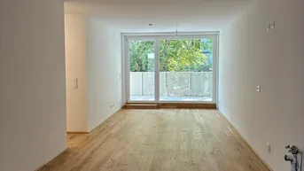 Helles, unmöbliertes Wohnzimmer mit Eichenparkettboden und großem Fenster mit Terrassenzugang.