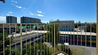 Sonniger Balkon mit Metallgeländer und weitem Blick über die städtische Umgebung.
