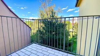 Balkon mit Fliesenboden und Metallgeländer, bietet einen grünen Ausblick auf die Umgebung.