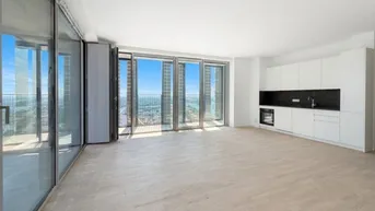 Helles, offenes Wohnzimmer mit integrierter Küche und raumhohen Fenstern mit Stadtblick.