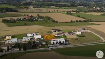 Luftaufnahme eines ländlichen Gebiets mit Wohnhäusern, Feldern und einem markierten Grundstück.
