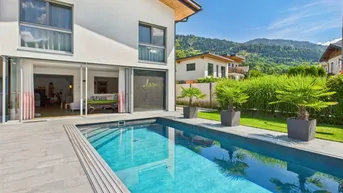 Modernes Einfamilienhaus mit Pool, Terrasse und Bergblick in sonniger Lage.
