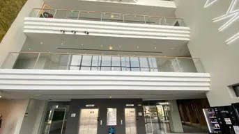 Geräumige und helle Lobby mit mehreren Aufzügen und offenen Galerien auf den oberen Etagen.