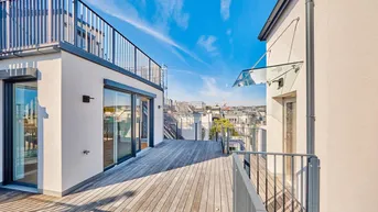Geräumige Dachterrasse mit Holzboden und modernem Geländer, bietet einen weiten Blick über die Stadt.