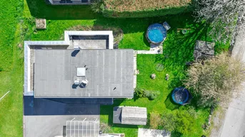 Luftaufnahme des Anwesens mit Flachdach, Garten, Pool und Carport.