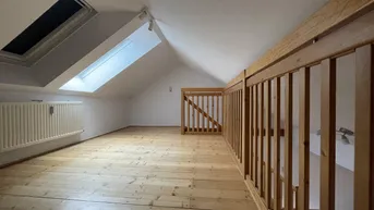 Helles Dachgeschoss mit Holzdielenboden und Dachfenstern, ideal als zusätzlicher Wohnraum.