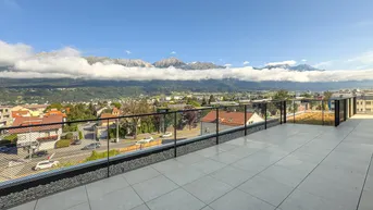 Große Dachterrasse mit Fliesenboden und weitem Blick auf die umliegende Berglandschaft.